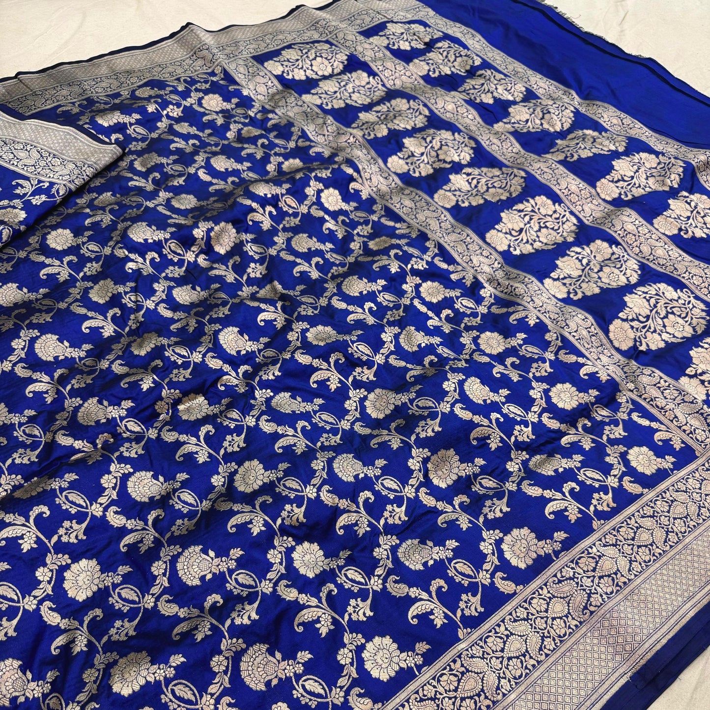 Blue saree with white floral patterns on a plain background