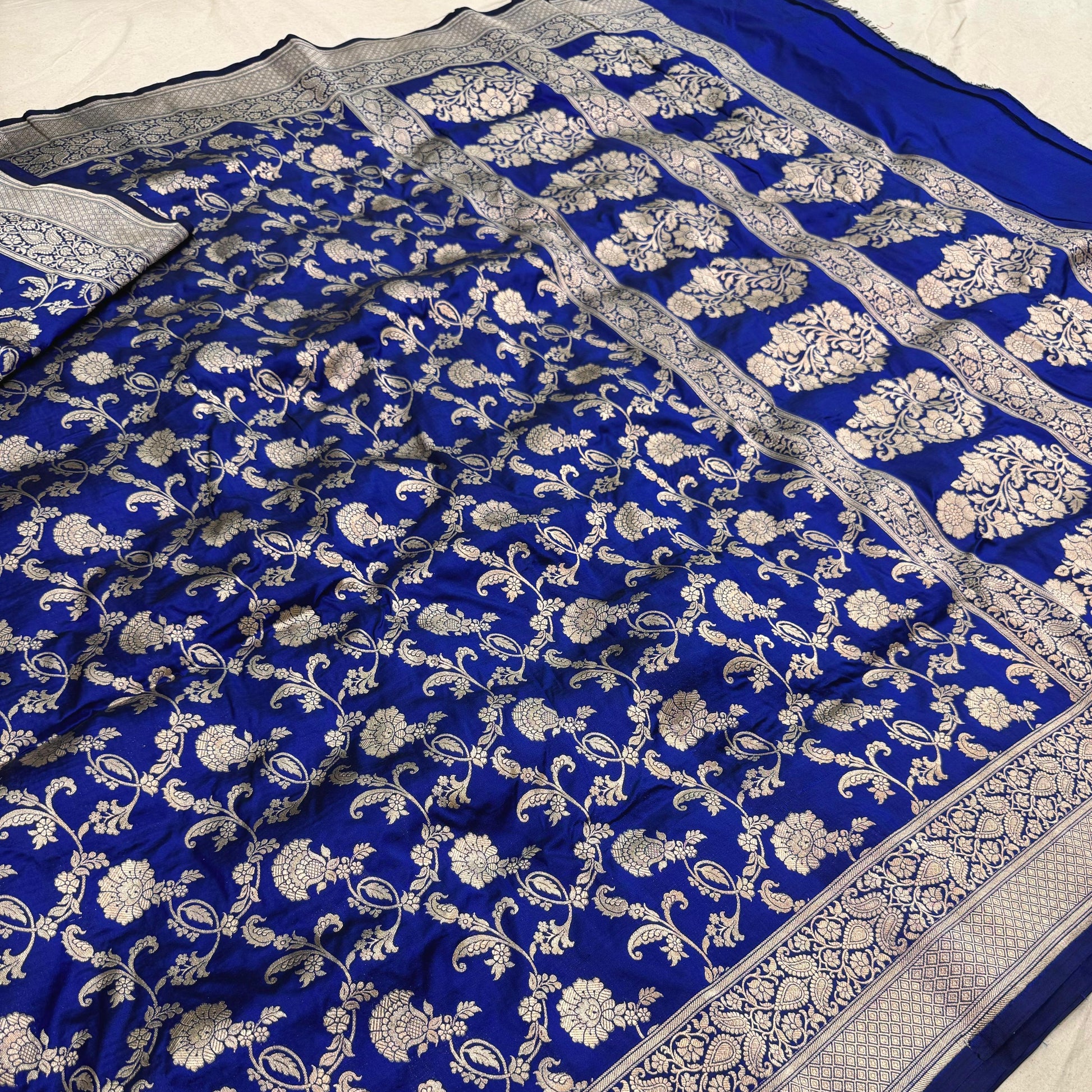 Blue saree with white floral patterns on a plain background